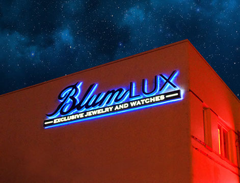 Bright blue neon sign reading "BlingLUX" on a building at night.