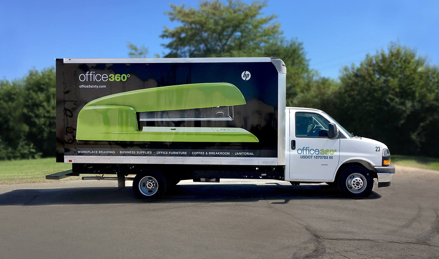 Bright green and black office furniture van with professional signage.