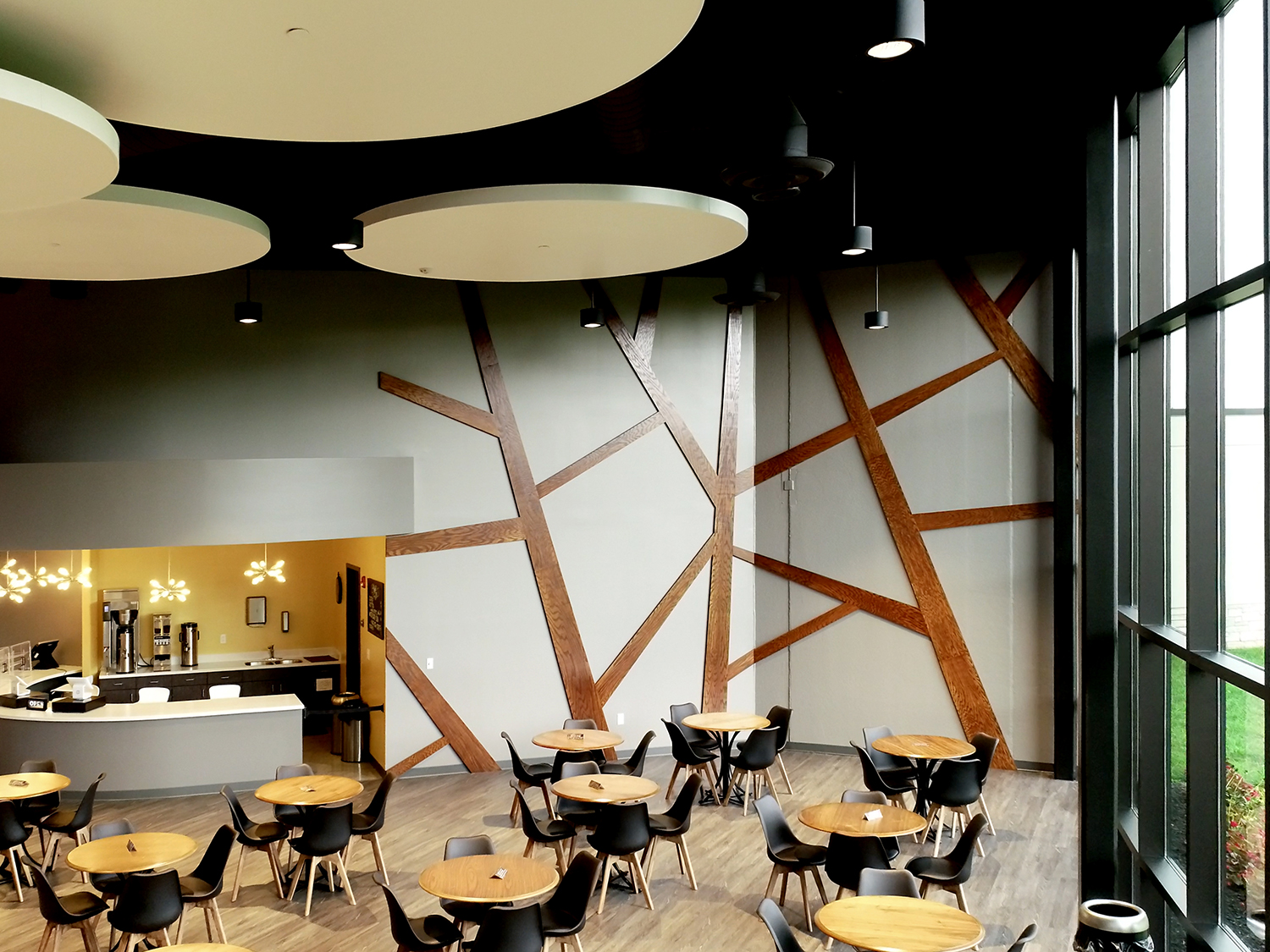 Modern interior cafe with custom wall signage and large glass windows.