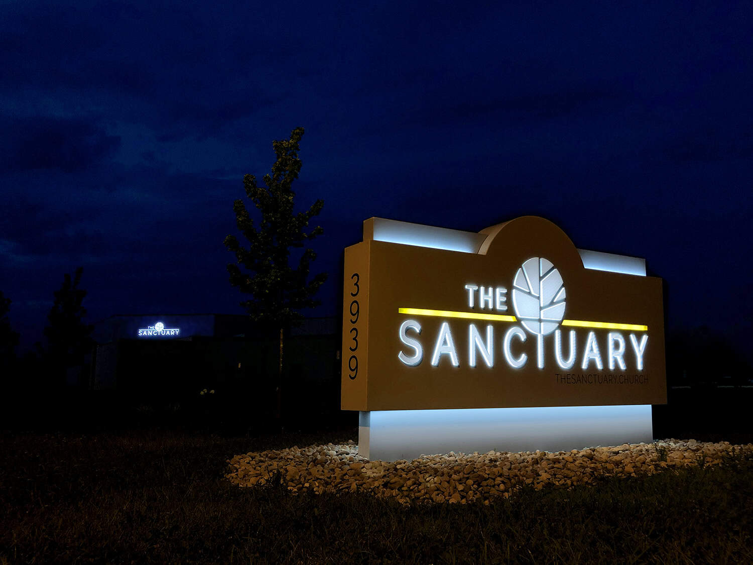 Illuminated church sign for The Sanctuary at night, showcasing custom outdoor signage.