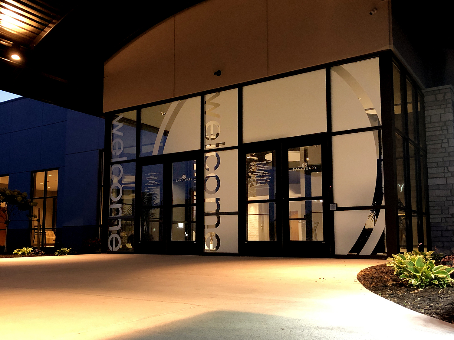 Modern commercial building with custom signage and illuminated entrance.
