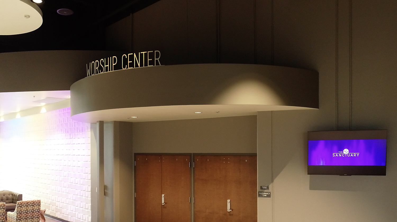 Worship centre signage with modern interior décor and digital screen.