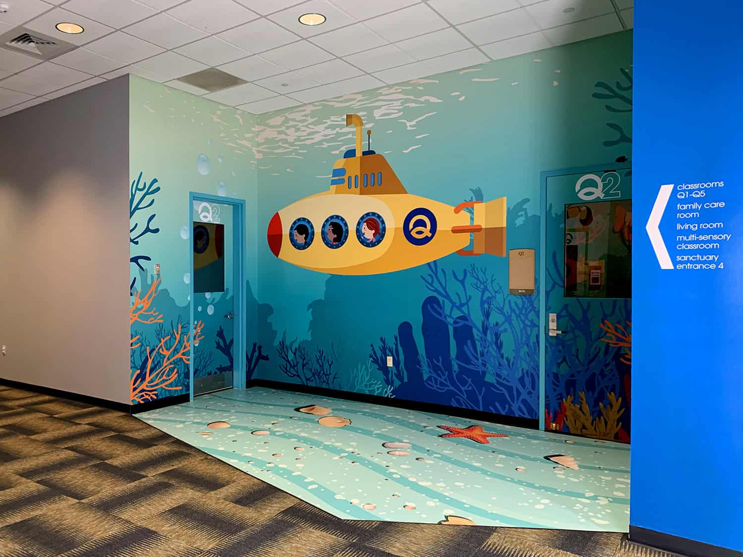 Colorful underwater-themed wall mural with submarine and marine life, perfect for children's spaces.