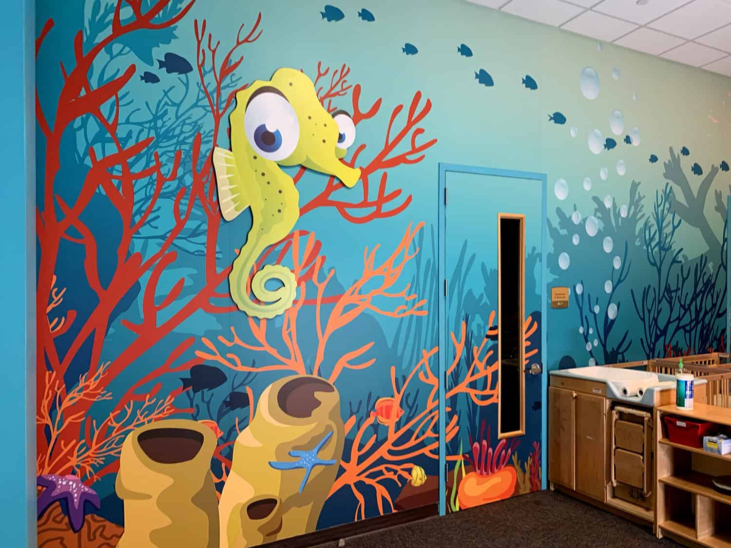 Vibrant underwater themed children's mural featuring sea creatures and coral art.