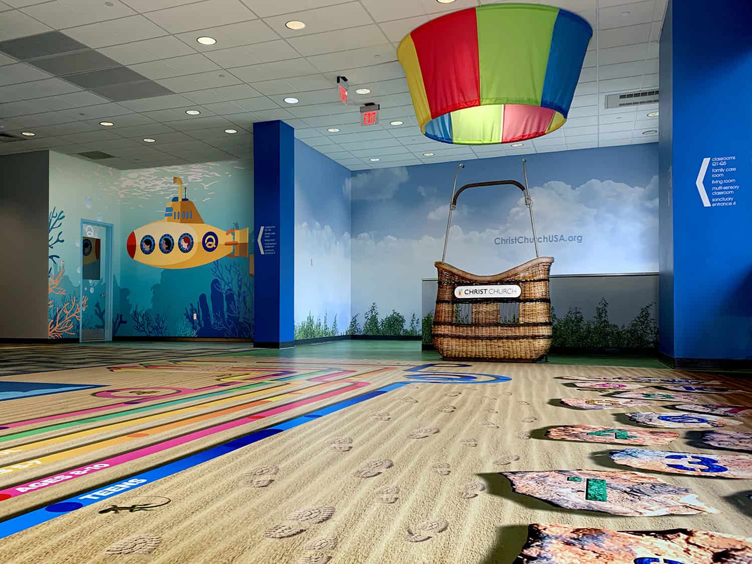 Bright underwater-themed children's play area with colorful wall murals and interactive signage.