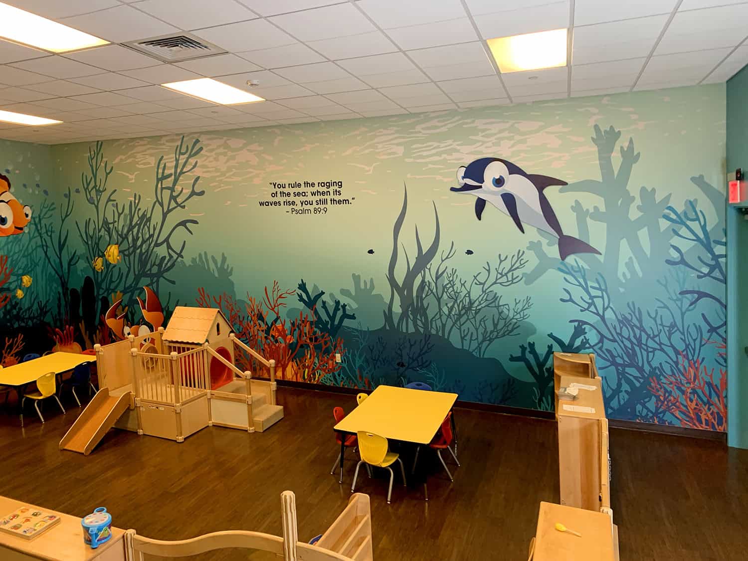 Vibrant underwater-themed children's playroom wall mural with ocean creatures and Scripture verse.
