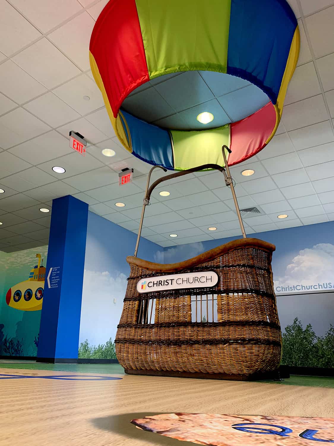Brightly coloured hot air balloon display at Christ Church indoor play centre, wall graphics, child-friendly signage.