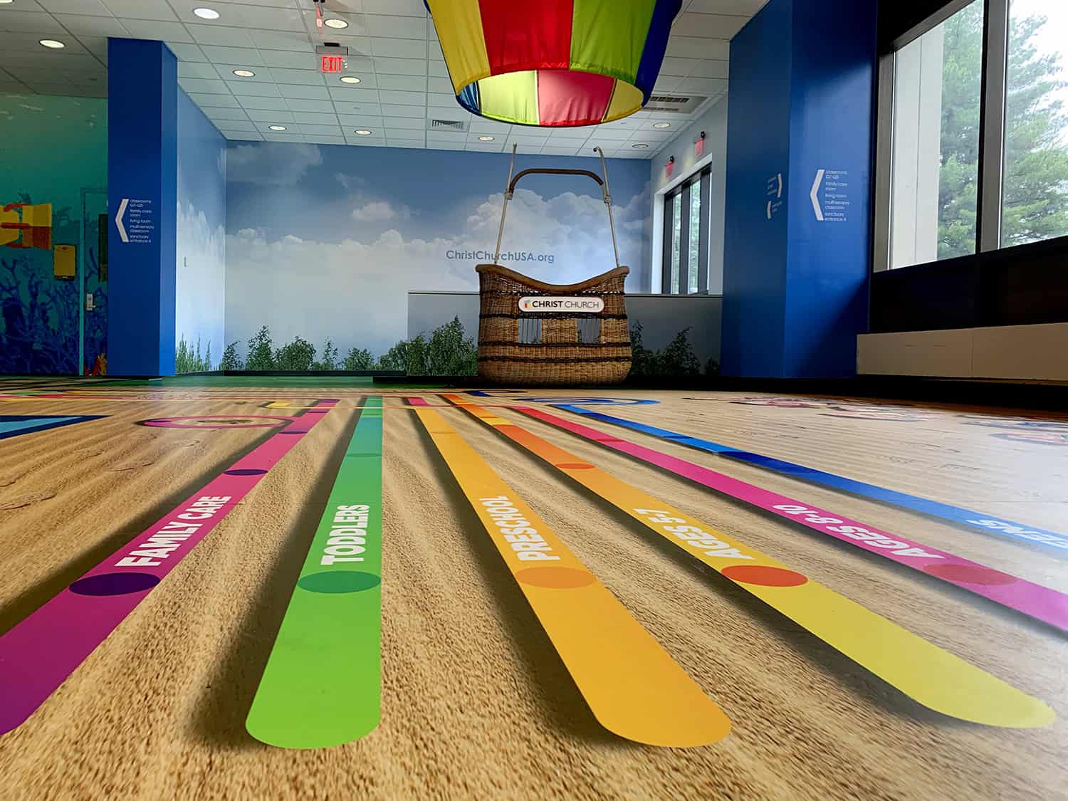 Colorful family activity floor decals at church event space in a modern indoor setting.