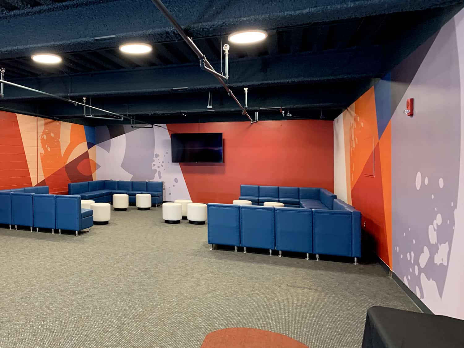 Colourful modern lounge area at Signworks office, vibrant wall art and comfortable seating.