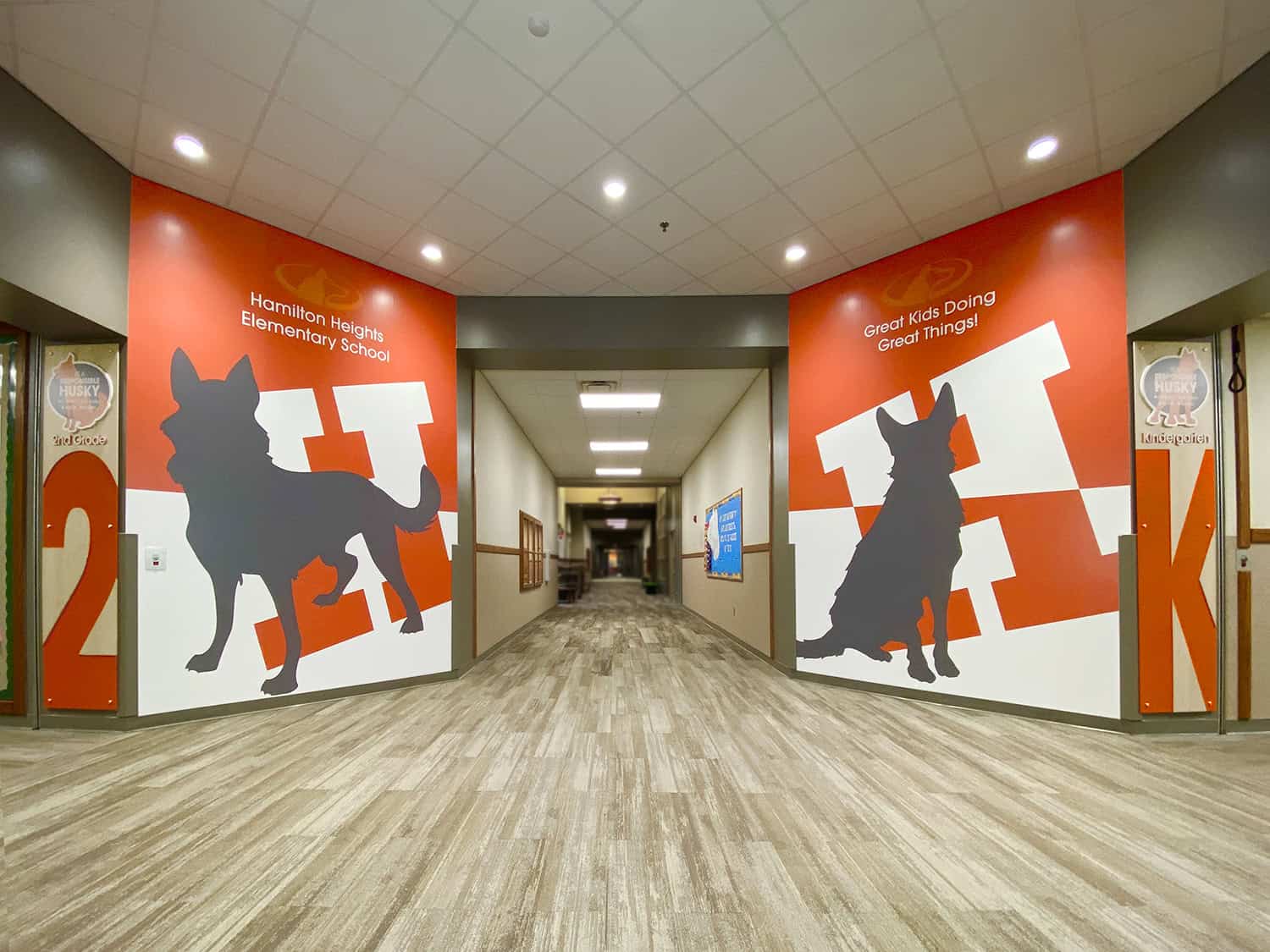 Vibrant school hallway wall murals featuring dog silhouettes and educational themes.