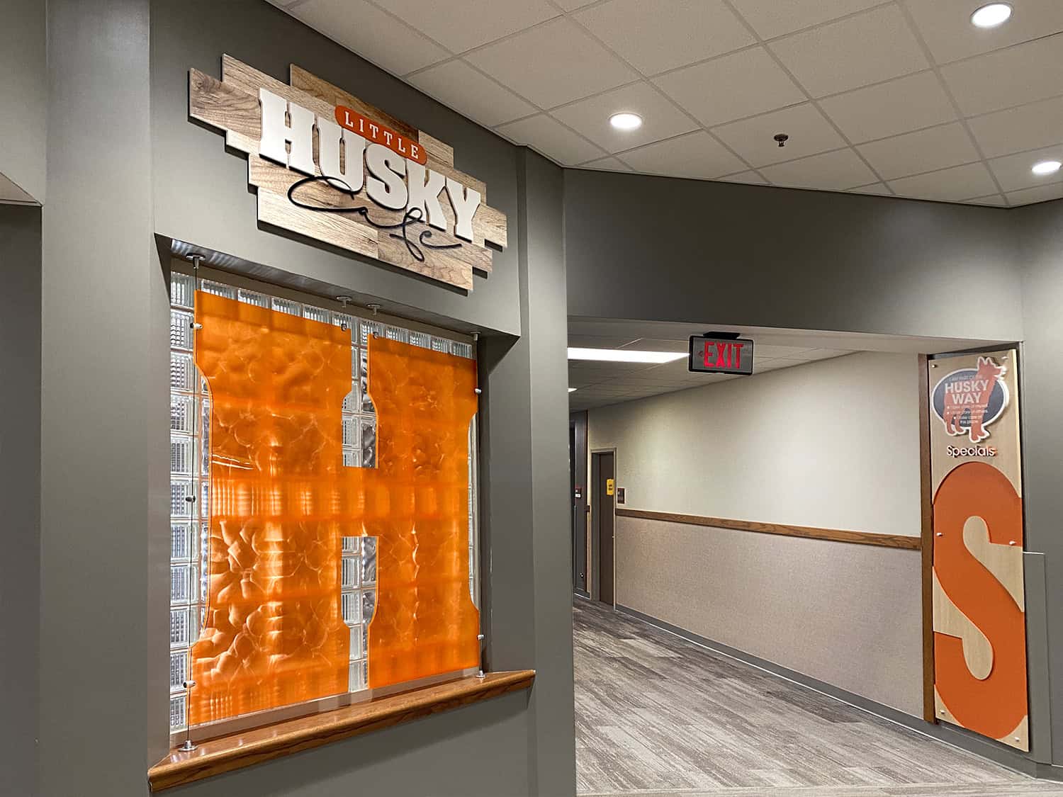 Bright indoor sign for Husky Café with custom wood and metal design elements.