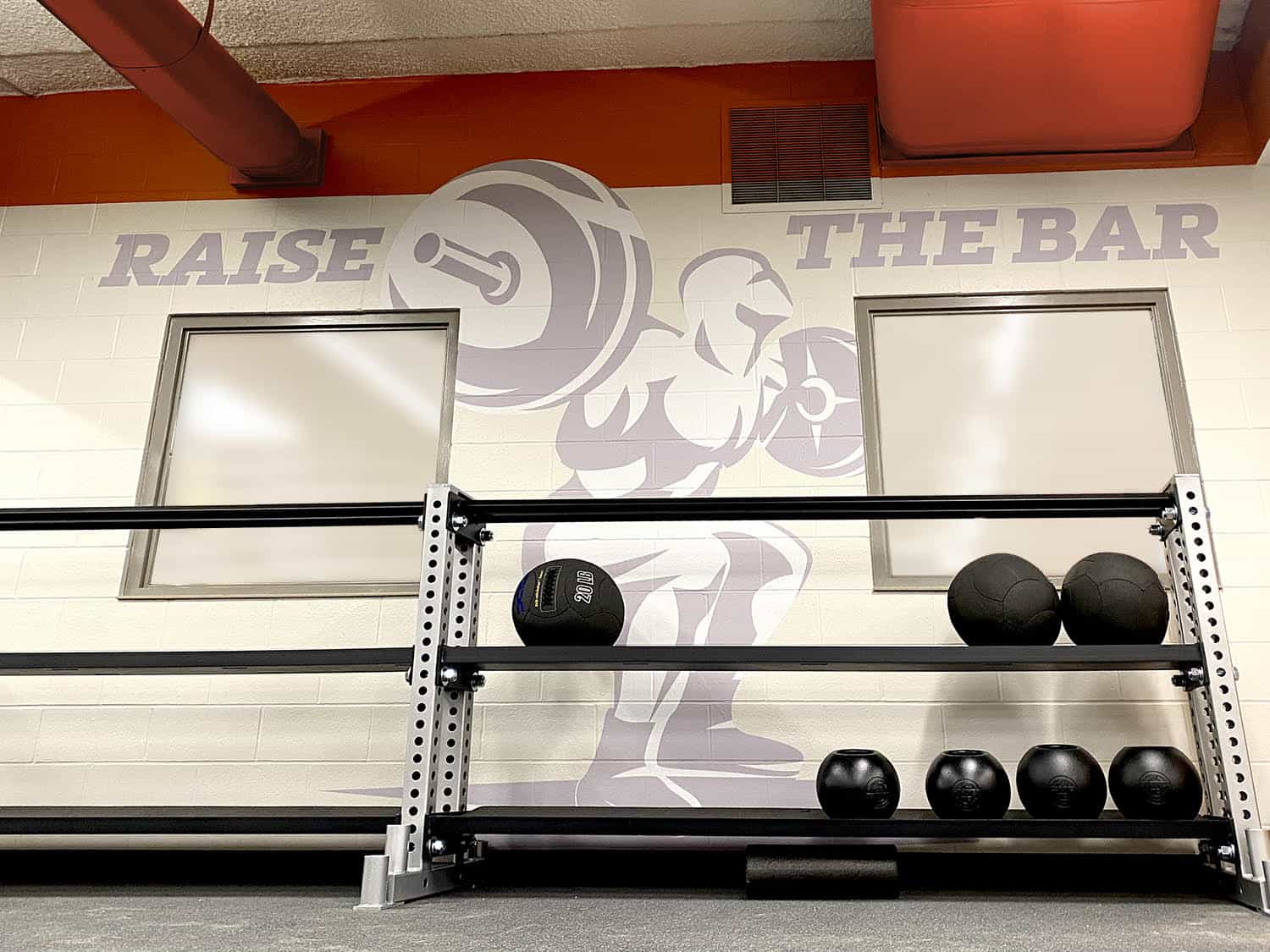 Vibrant gym wall decal with motivating slogan and weightlifting graphic.