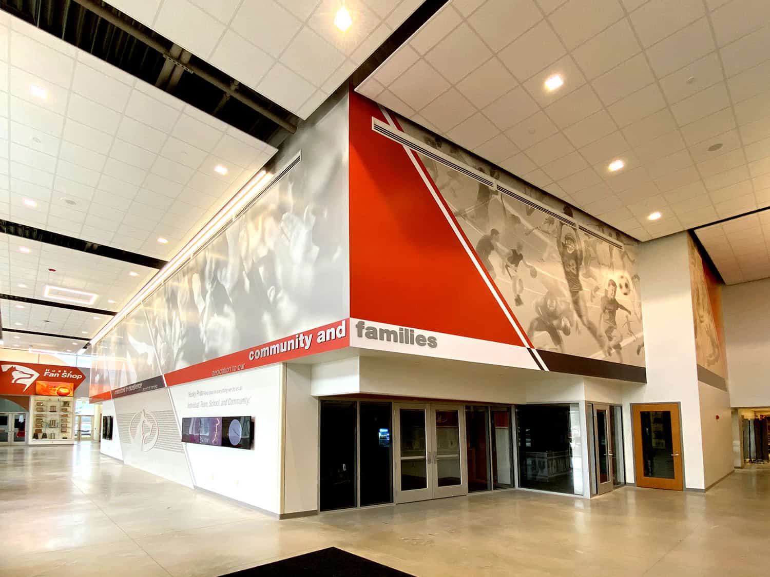 Vibrant urban sign artwork promoting community and families at an indoor shopping mall.