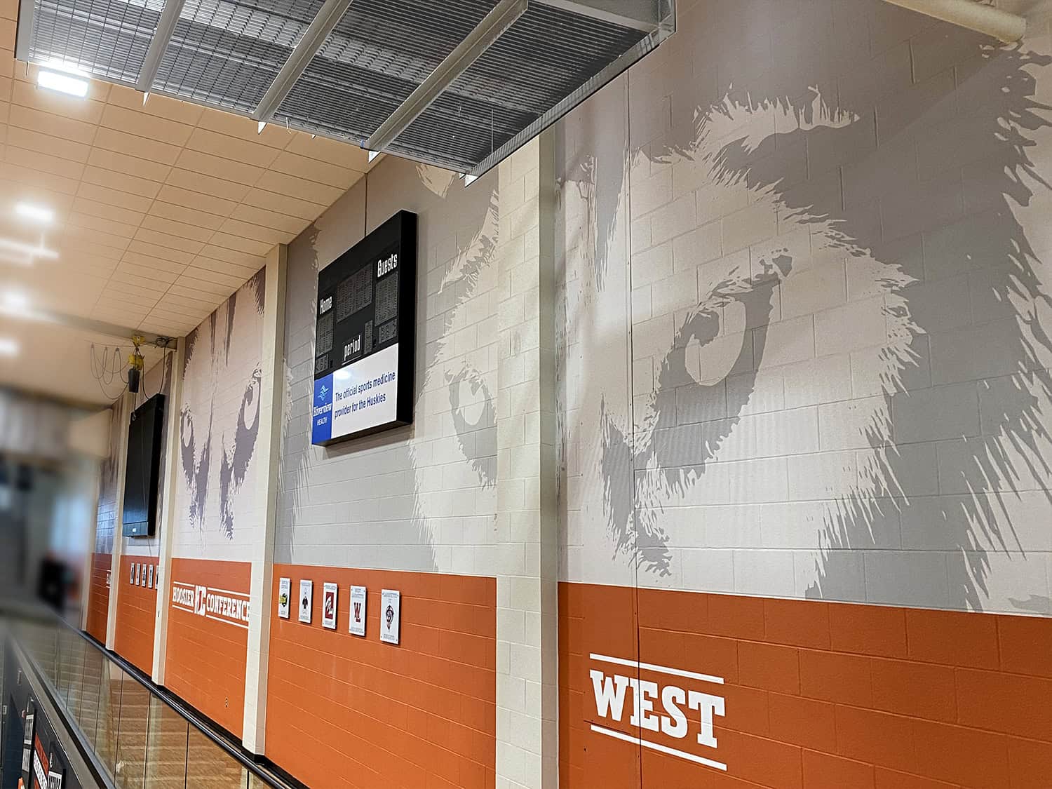 Large sports team murals on wall with West conference branding.