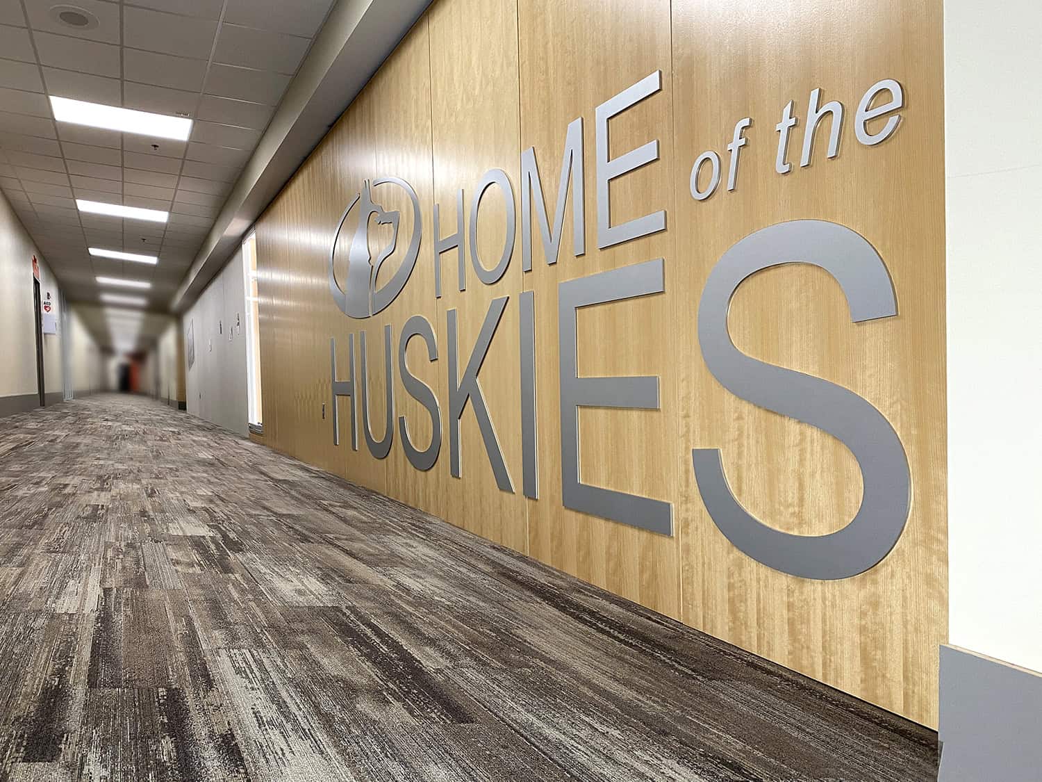Modern office corridor with custom wall signage for Home of the Huskies.