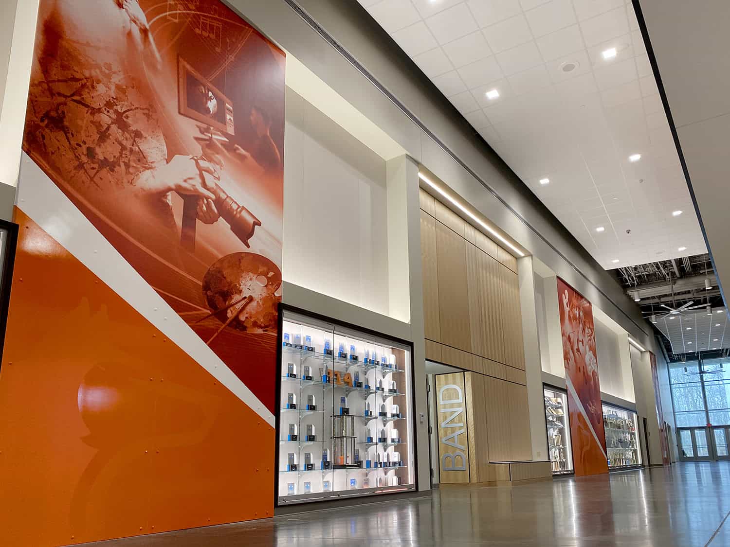 Vibrant orange signage with digital displays and modern interior design at a shopping mall.