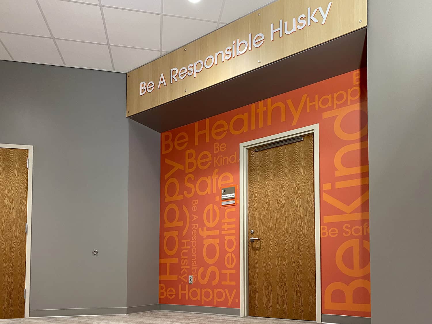 Bright orange and red health and safety signage wall with motivational messages at Signworks, Australian signage experts.