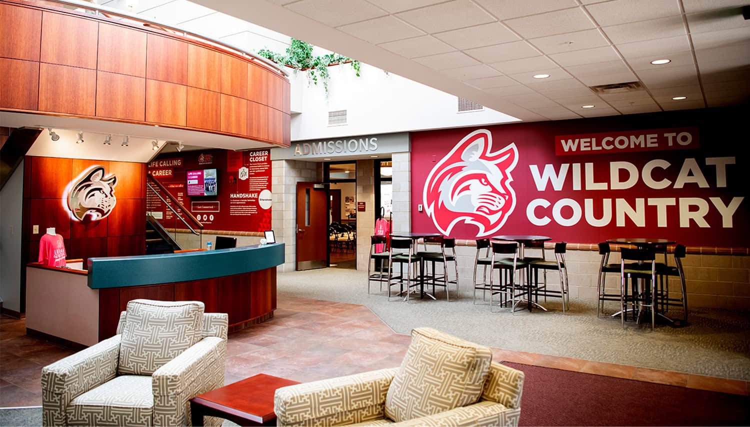 Bright school lobby with Wildcats country sign and student entrance area.