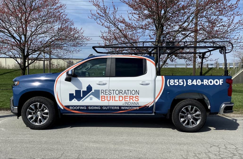 Custom commercial truck with signage for roofing and siding services.