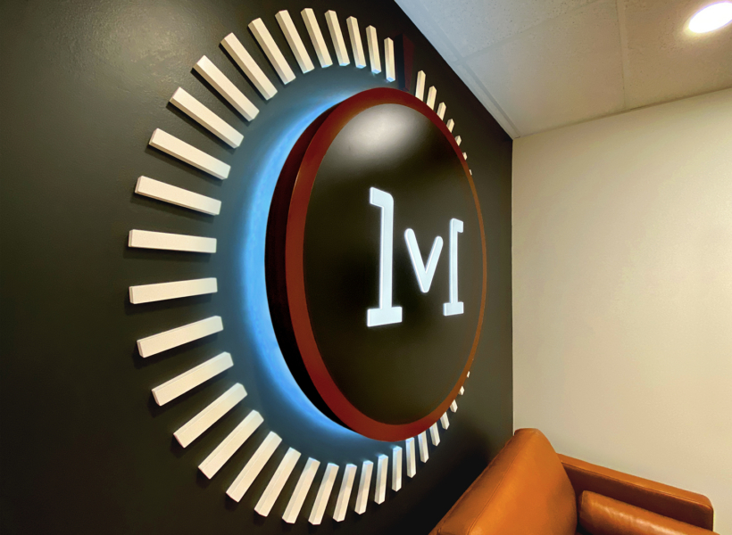 Illuminated logo sign with backlit LED lighting for business branding.