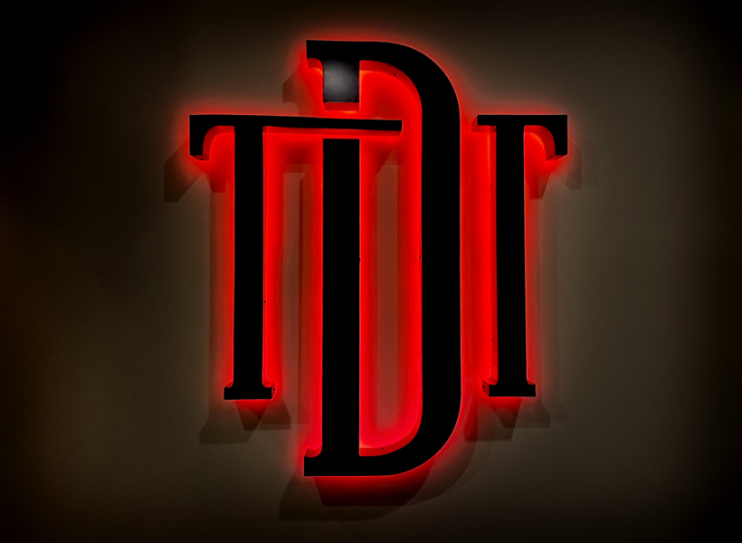 Illuminated neon sign with red backlight - custom signage for business branding.