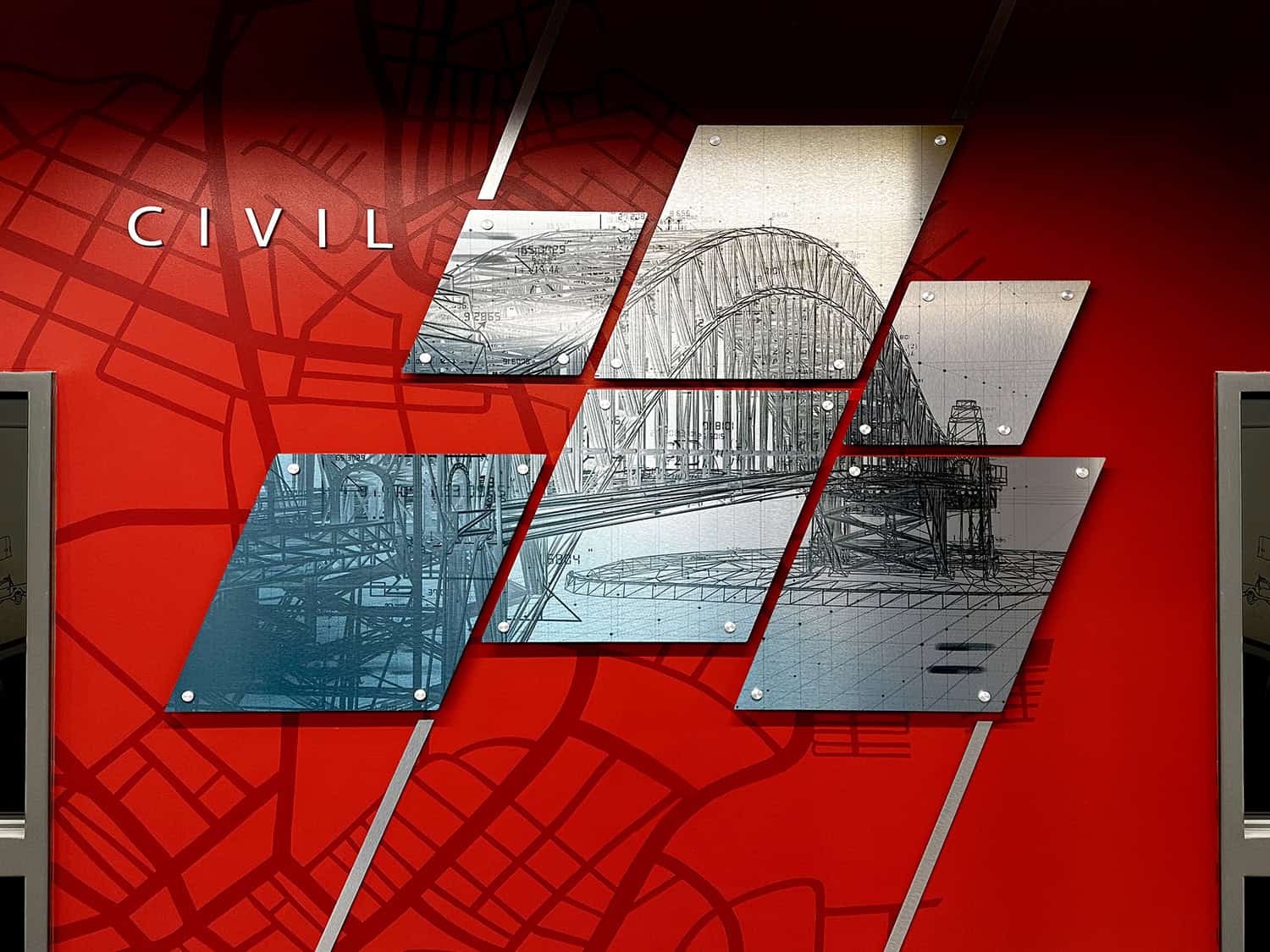 Modern architectural display showcasing bridge construction blueprints and engineering plans on a red wall with map graphics.