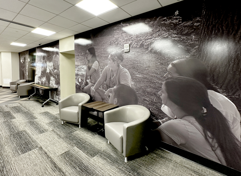 Vivid indoor mural featuring diverse people sitting and engaging, large black-and-white photo.