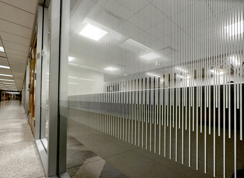 Sleek modern interior glass partition with vertical stripe design, commercial signage solution.