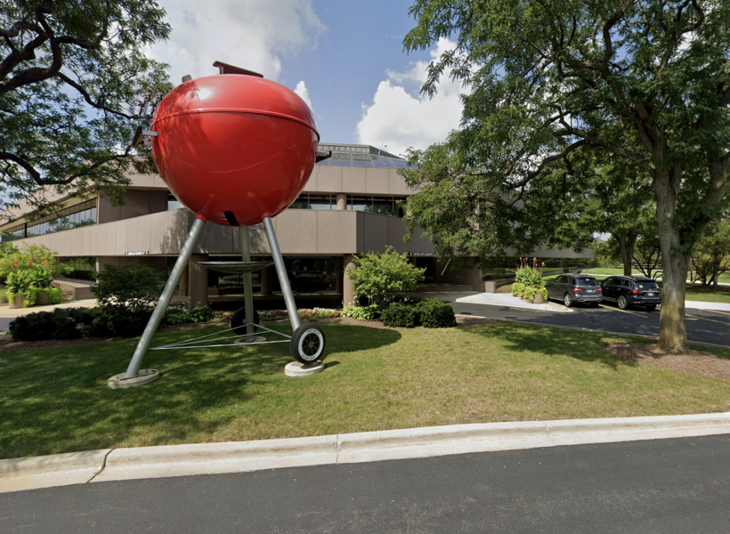 Large red barbecue sculpture outside a modern office building, corporate signage, custom outdoor signage, creative signage solutions, Signworks signage expertise.