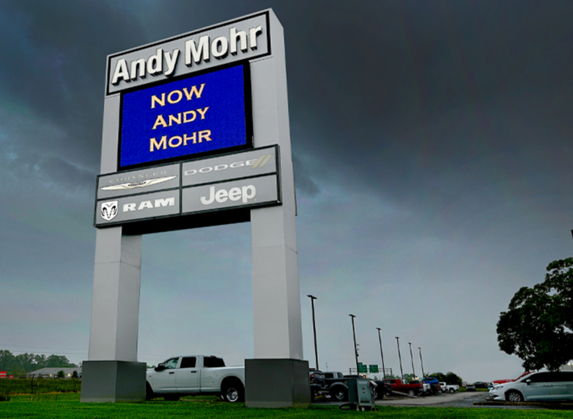 Illuminated commercial sign with dealership branding for Dodge, Jeep, RAM, and Chrysler.