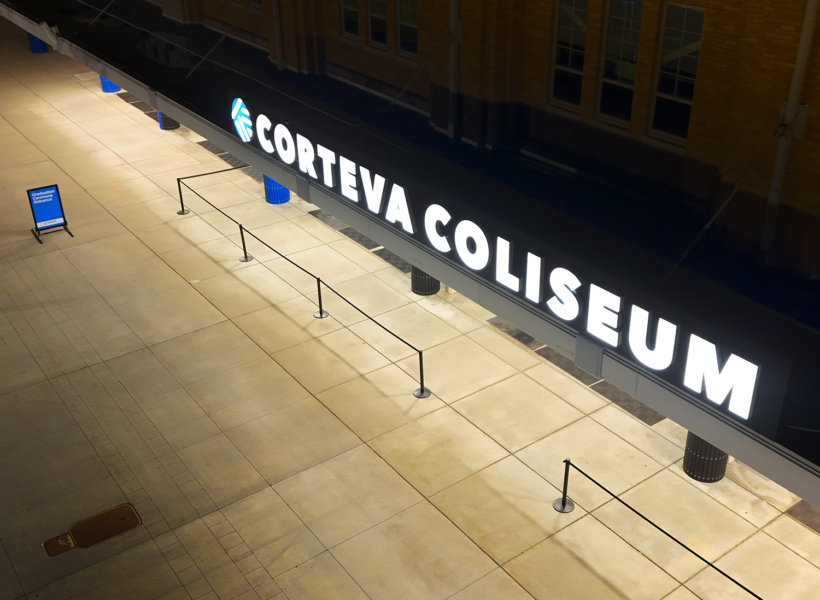 Illuminated sign for Corteva Colliseum at night.